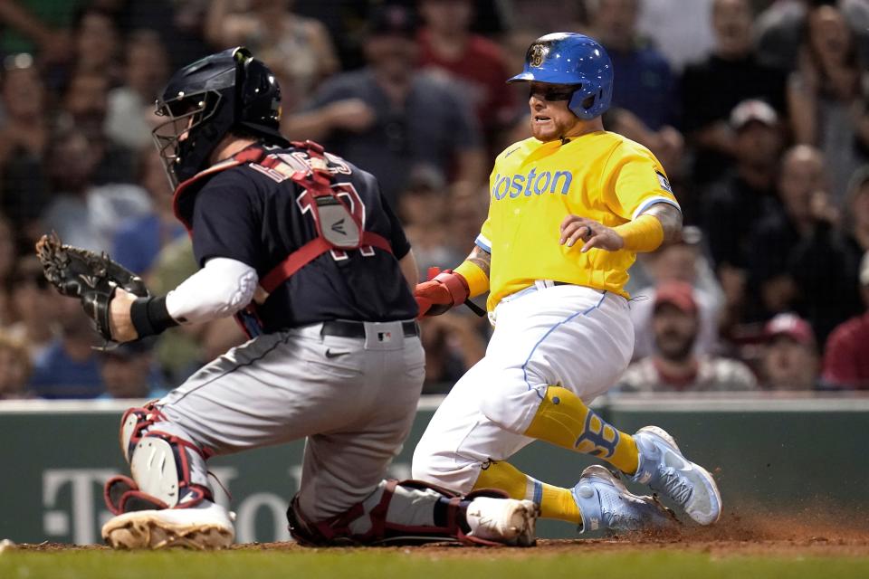 Boston Red Sox's Christian Vazquez, right, scores on a double by Franchy Cordero as the ball gets away from Cleveland Guardians catcher Austin Hedges (17) during the fourth inning of a baseball game at Fenway Park, Wednesday, July 27, 2022, in Boston. (AP Photo/Charles Krupa)