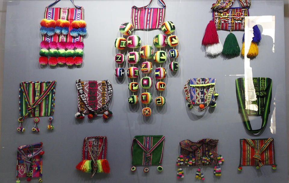 In this Sept. 13, 2019 photo, indigenous handmade bags that were given as gifts to Bolivia's President Eva Morales, are displayed at the Democratic and Cultural Revolution Museum in Orinoca, Bolivia. The museum contrasts with the humble village of Orinoca, with its farmers, llama shepherds and a population of less than 1,000 people. Poverty is visible along its cobbled streets and adobe houses. Only a few streets are paved, and many homes lack potable water and sewage systems. (AP Photo/Juan Karita)