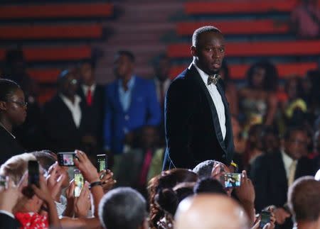 Jamaican Olympic gold medallist Usain Bolt (R) arrives for an event in Kingston, Jamaica, October 15, 2016. Picture taken October 15, 2016. REUTERS/Gilbert Bellamy