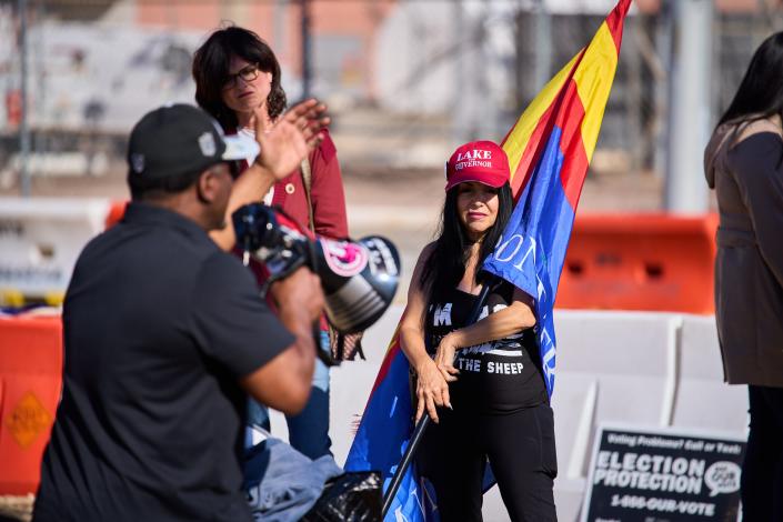 A supporter of Republican candidate for governor Kari Lake listens to Jerone Davison, who ran for election in Arizona Congressional District 4, outside the Maricopa County Tabulation and Election Center in Phoenix on Monday, Nov 14, 2022.