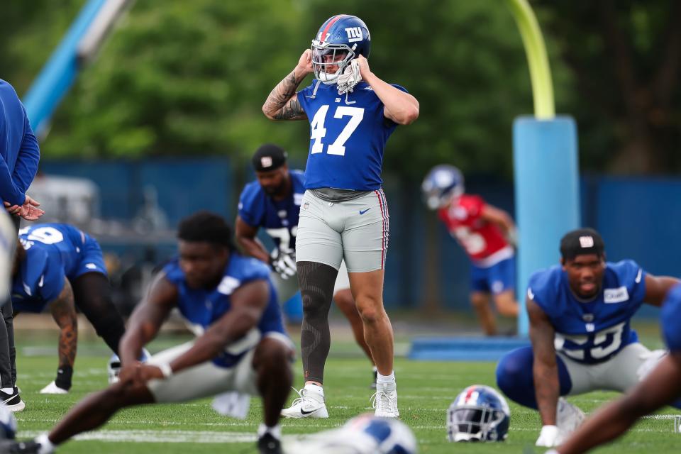 EAST RUTHERFORD, NEW JERSEY - JUNE 06: Theo Johnson #47 of the New York Giants puts on his helmer during New York Giants OTA Offseason Workouts at NY Giants Quest Diagnostics Training Center on June 06, 2024 in East Rutherford, New Jersey. (Photo by Luke Hales/Getty Images)