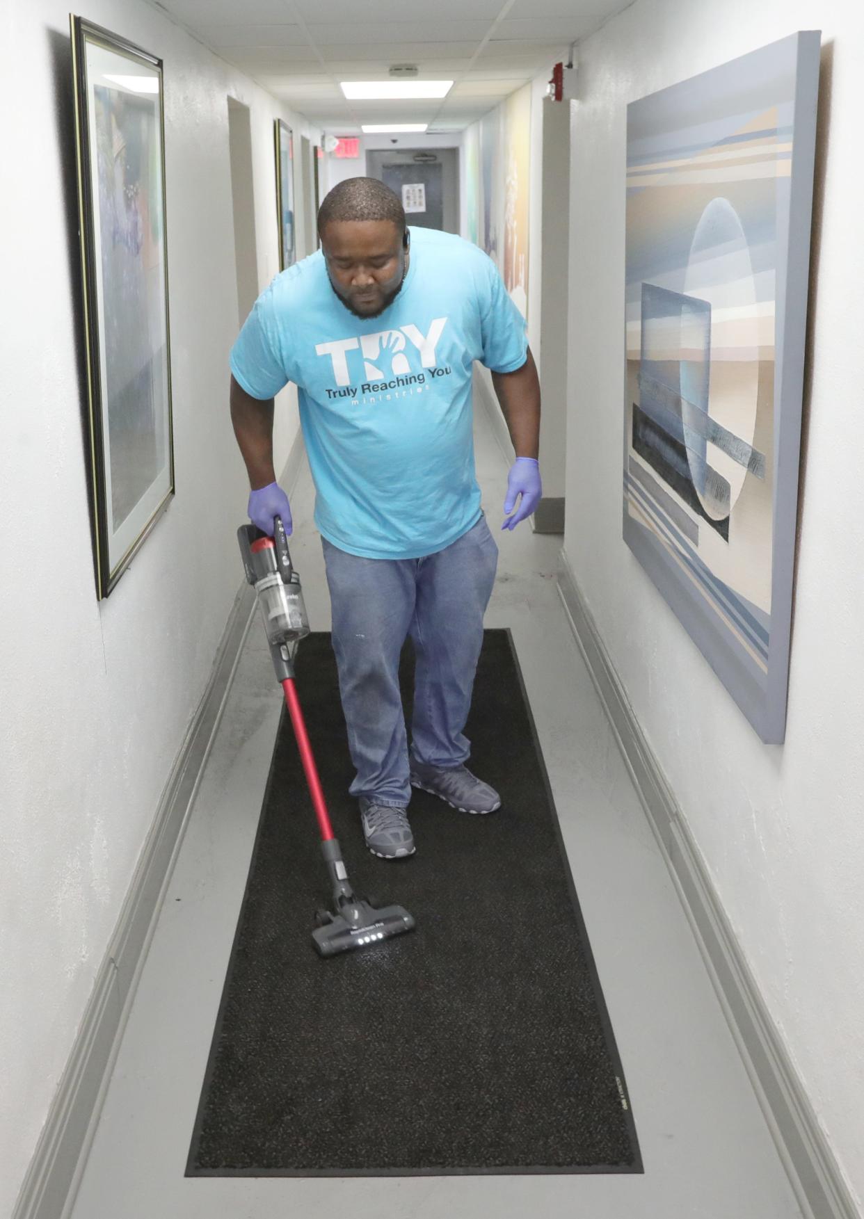 Edrick Mayfield runs a vacuum at an apartment building on Copley Road in Akron as part of his work with the TRY program.