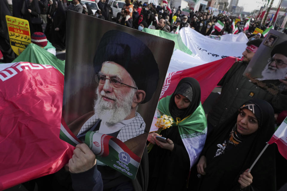 Demonstrators carry a huge Iranian flag and posters of the Supreme Leader Ayatollah Ali Khamenei during the annual rally commemorating Iran's 1979 Islamic Revolution, in Tehran, Iran, Saturday, Feb. 11, 2023. Iran on Saturday celebrated the 44th anniversary of the 1979 Islamic Revolution amid nationwide anti-government protests and heightened tensions with the West. (AP Photo/Vahid Salemi)