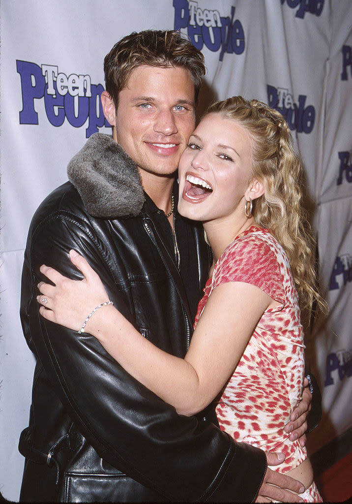 Nick Lachey and Jessica Simpson smiling with their arms around each other
