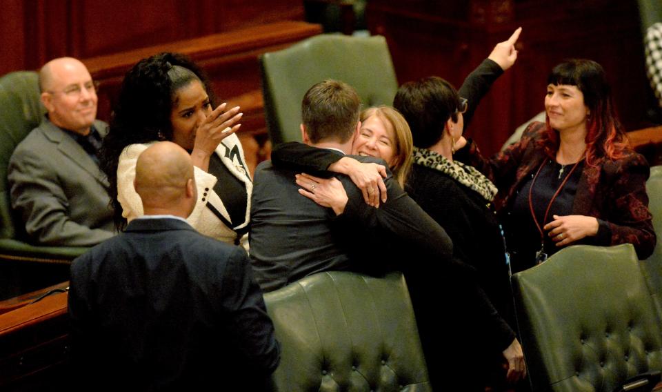 Rep. Jennifer Gong-Gershowitz, D-Glenview, center hugging, celebrates on the House floor with other Democrats after the passage of House Bill 1095 which amended the SAFE-T Act, Thursday Dec. 1, 2022