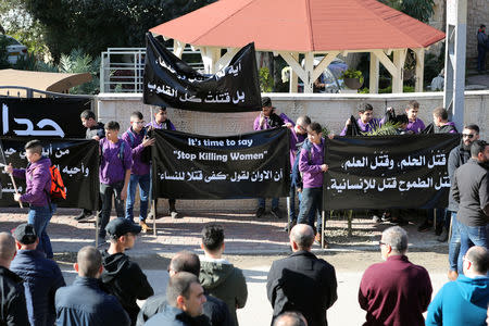 Teenagers hold banners with Arabic writing ahead of the funeral of Aiia Maasarwe, 21, an Israeli student killed in Melbourne, in her home town of Baqa Al-Gharbiyye, northern Israel January 23, 2019. The banner on the right reads: " Killing the dream, killing education, killing ambition, killing humanity " REUTERS/Ammar Awad