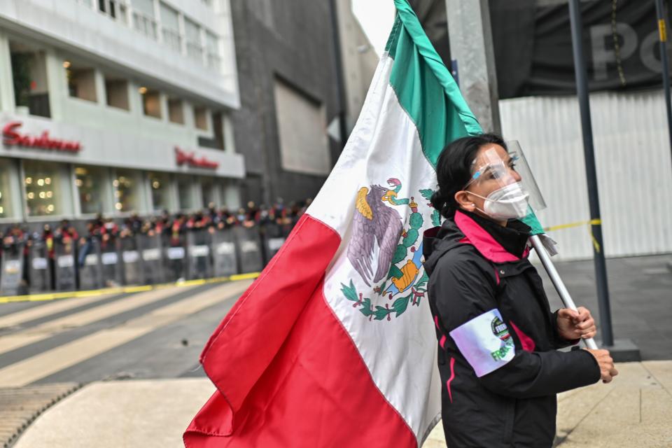 A member of the National Front Anti-AMLO (Frena), who will make a second attempt to reach Zocalo Square to protest against Mexican President Andres Manuel Lopez Obrador (ALMO), holds a Mexican flag as they camp on Juarez street in Mexico City on September 20, 2020, a day after being prevented by the local police to get to the city's main square, amid the COVID-19 novel coronavirus pandemic. (Photo by Pedro PARDO / AFP) (Photo by PEDRO PARDO/AFP via Getty Images)