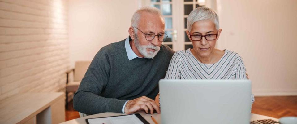 Couple de personnes âgées naviguant sur Internet ensemble