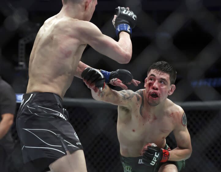 Brandon Moreno, right, throws a punch at Kai Kara-France in a mixed martial arts interim flyweight title bout at UFC 277 on Saturday, July 30, 2022, in Dallas. (AP Photo/Richard W. Rodriguez)