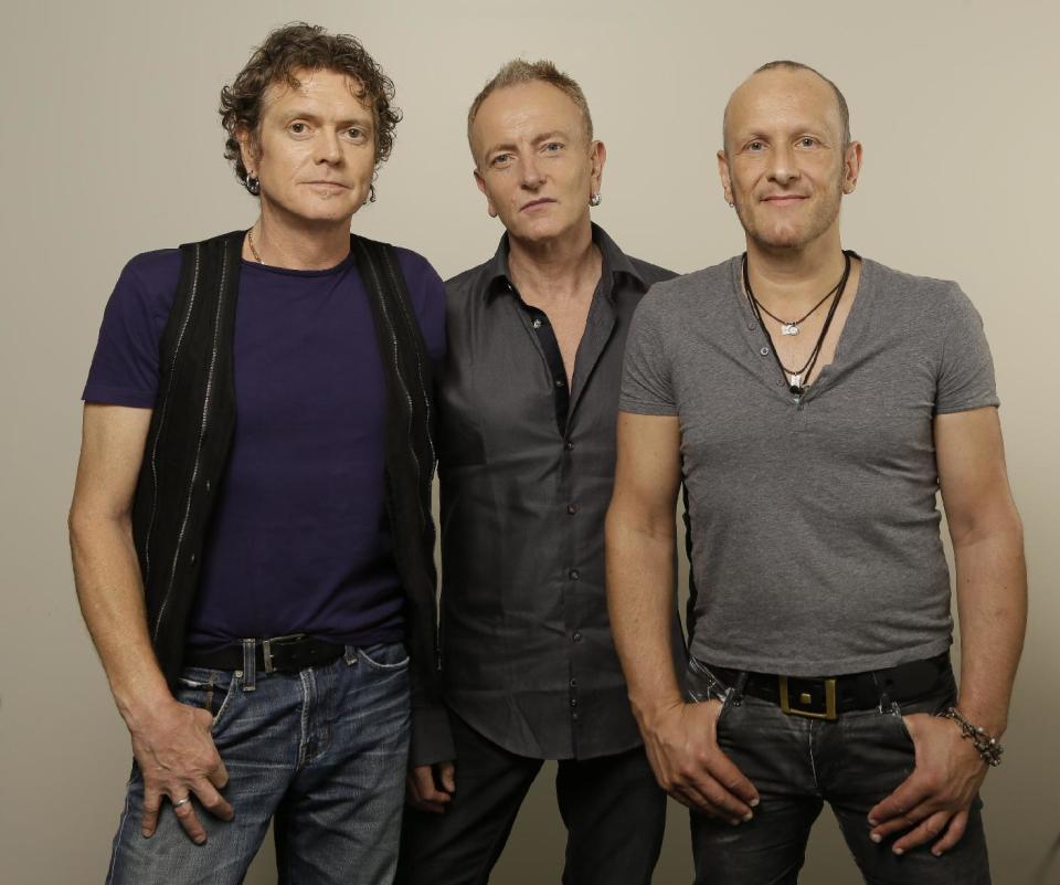 In this photo taken Wednesday, Sept. 25, 2013, British rock group, Def Leppard, from left, Rick Allen, Phil Collen and Vivian Campbell pose for a photo in Los Angeles. First up, in a year of firsts for the band, is the special-event screening Wednesday, Oct. 1, 2013, (and again on Oct. 8) of their live concert film at theaters nationwide “Def Leppard Viva! Hysteria Concert.” (AP Photo/Damian Dovarganes)