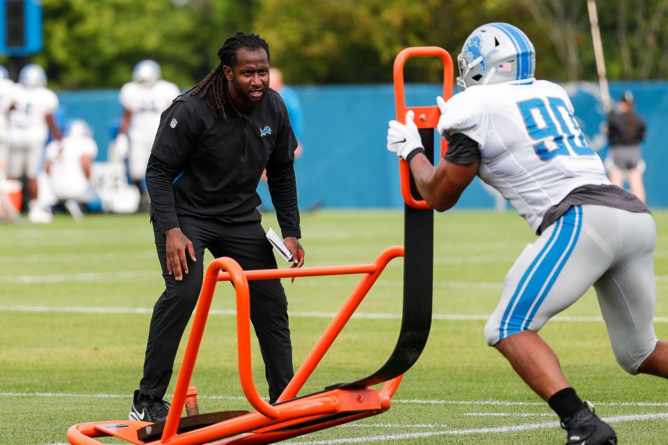 Detroit Lions outside linebacker coach Kelvin Sheppard watches defensive end Trey Flowers (90) practice  during training camp at practice facility in Allen Park, Tuesday, August 10, 2021.