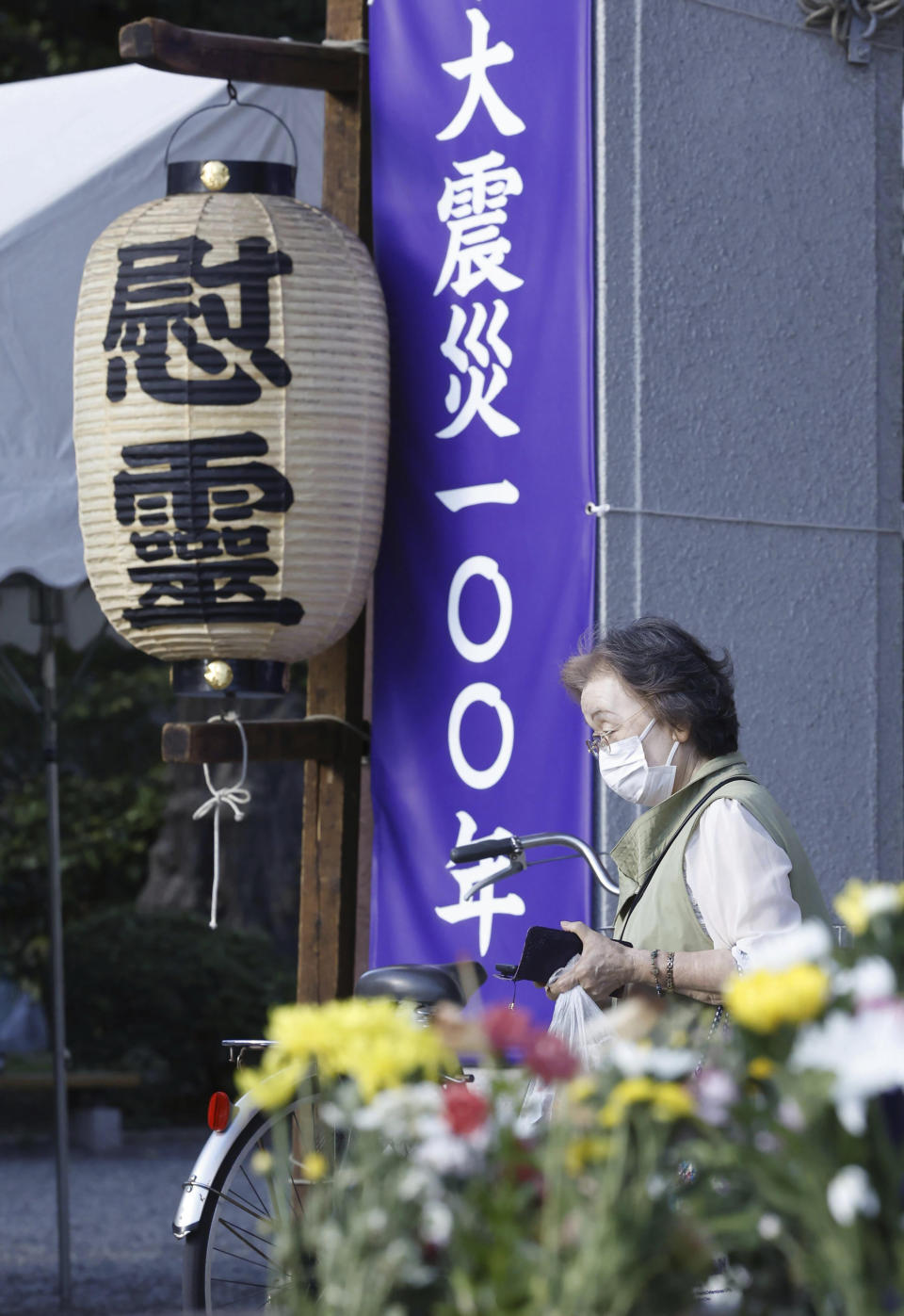 A bereaved relative visits Tokyo Metropolitan Memorial Hall, which enshrines the remains of the victims of the Great Kanto Quake and air raid on Tokyo, in Tokyo Friday, Sept. 1, 2023. On Friday, Japan marked the centennial of the 1923 Great Kanto Quake that killed more than 100,000. Words on a lantern read "Memorial," and on a banner read "Great earthquake 100 years." (Kyodo News via AP)