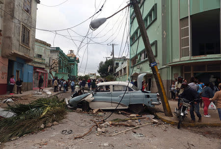 People walk past debris after a tornado ripped through a neighbourhood in Havana, Cuba January 28, 2019. REUTERS/Fernando Medina