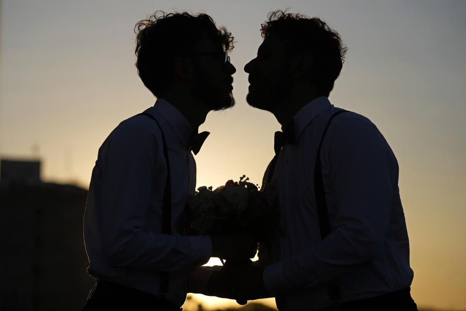 Guilherme Tavares and Sergio Murilo celebrate after they were joined in matrimony at a same sex mass wedding ceremony, organized to mark Pride Month in Goiania, Brazil, Friday, June 28, 2024. (AP Photo/Eraldo Peres)