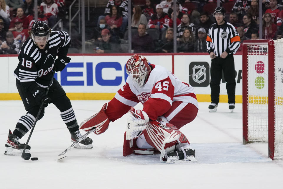 New Jersey Devils' Dawson Mercer, left, scores on Detroit Red Wings goaltender Magnus Hellberg during the first period of an NHL hockey game in Newark, N.J., Friday, April 29, 2022. (AP Photo/Seth Wenig)