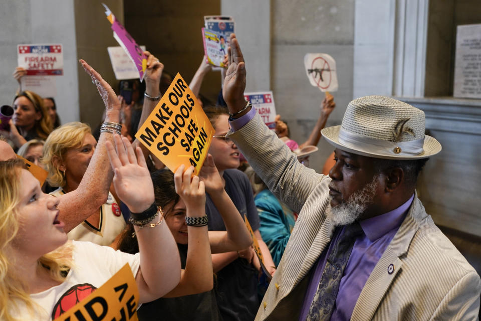 Rep. Antonio Parkinson, D-Memphis, right, high-fives with demonstrators outside the House chamber during a special session of the state legislature on public safety Monday, Aug. 28, 2023, in Nashville, Tenn. (AP Photo/George Walker IV)