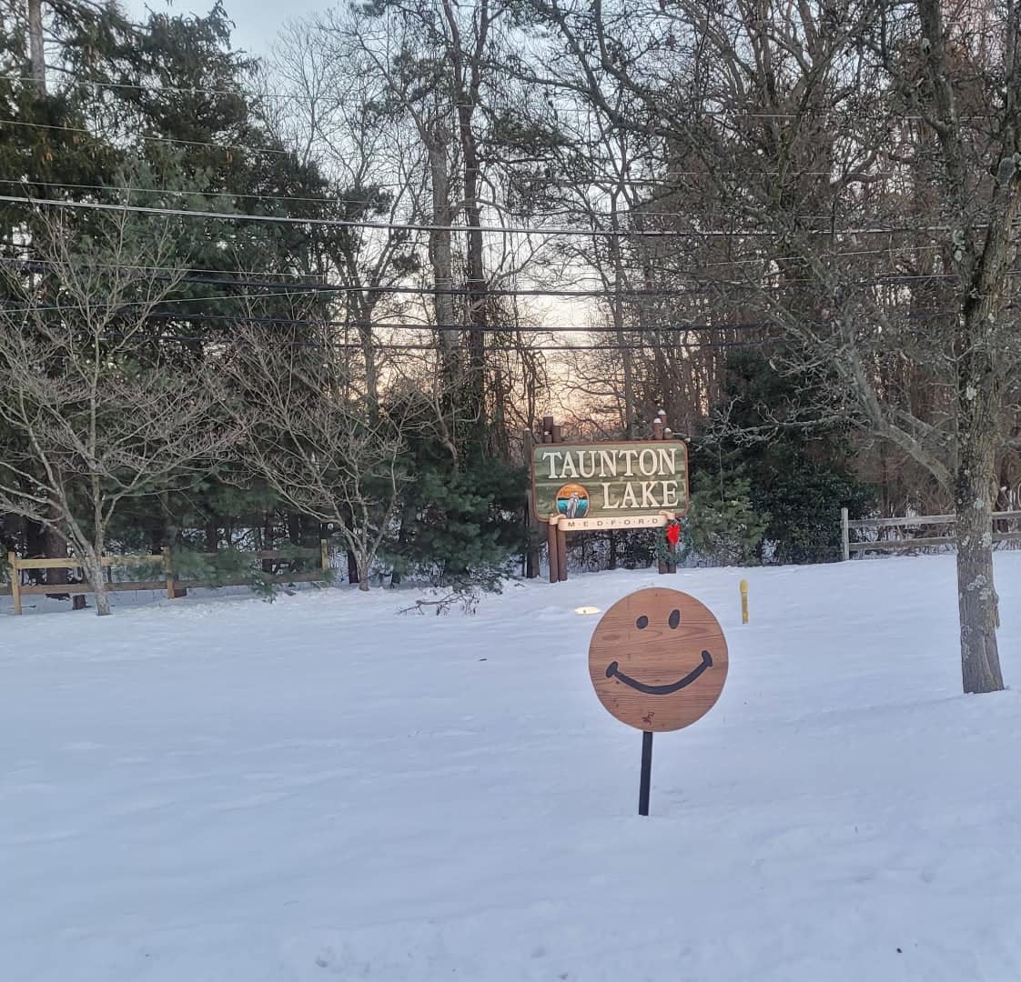 A mysterious series of smiley face signs have been springing up by Taunton Lake for a few years now, and Medford residents want to know who to thank.