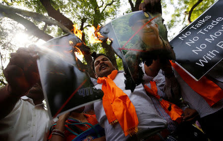 Members of Hindu Sena, a right wing Hindu group, burn posters of Pakistan's Prime Minister Nawaz Sharif and Pakistan's army chief Lieutenant General Qamar Javed Bajwa during a protest in New Delhi, India, May 2, 2017, against the killing of two Indian soldiers who were patrolling the de facto border in the disputed Kashmir region on Monday. REUTERS/Adnan Abidi