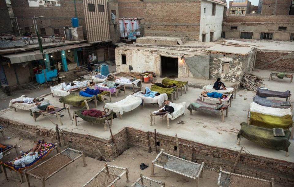 People rest on beds on a rooftop during a load-shedding power outage in Jacobabad, Pakistan, on Friday, May 27, 2022.