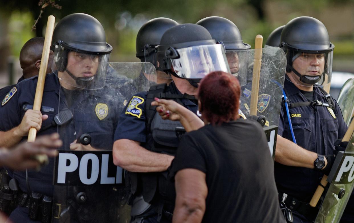 A protester yells at police in front of the Baton Rouge Police Department headquarters after police arrived in riot gear to clear protesters from the street in Baton Rouge, La., Saturday, July 9, 2016. Several protesters were arrested. (AP Photo/Max Becherer)