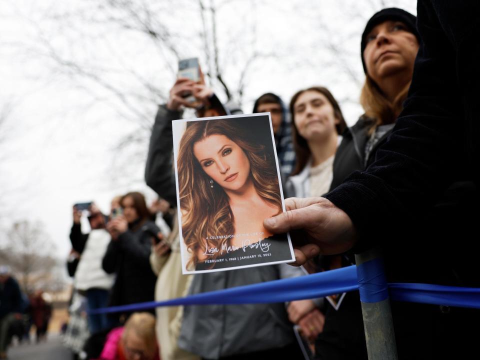 A fan of Lisa Marie Presley holds the program for her memorial service.