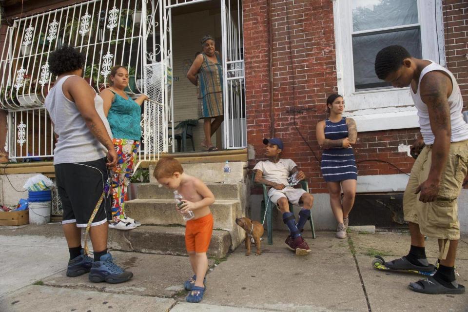 People congregate on a rowhouse stoop in the historically Puerto Rican Hunting Park neighbourhood in North Philadelphia (Mark Makela for The Washington Post)