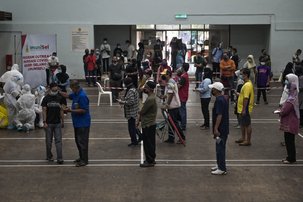 People wait in line for a Covid-19 public community screening by Selcare in Hulu Kelang, May 18, 2021. — Picture by Miera Zulyana