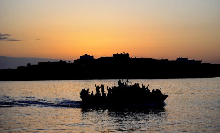 A boat carring Tunisian migrants enters the port of Lampedusa on April 12, 2011.Italian coast guard and navy vessels on Wednesday rescued nearly 400 migrants on three boats ahead of a visit by Pope Francis next week to the tiny island of Lampedusa -- a gateway for undocumented migrants and refugees into the European Union