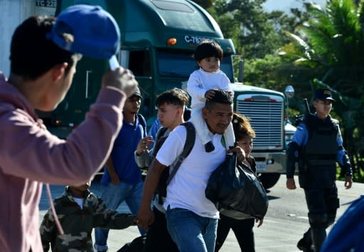 Honduran migrants cross the border between Honduras and Guatemala after breaking through a police fence in Corinto, Honduras