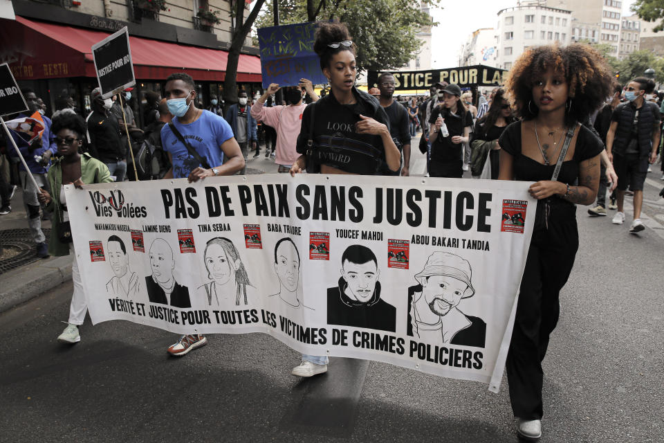 People march holding a banner that reads "No country without justice- Truth and justice for all the victims of police crimes" during a protest in memory of Lamine Dieng, a 25-year-old Franco-Senegalese who died in a police van after being arrested in 2007, in Paris, Saturday, June 20, 2020. Multiple protests are taking place in France on Saturday against police brutality and racial injustice, amid weeks of global anger unleashed by George Floyd's death in the US. (AP Photo/Christophe Ena)