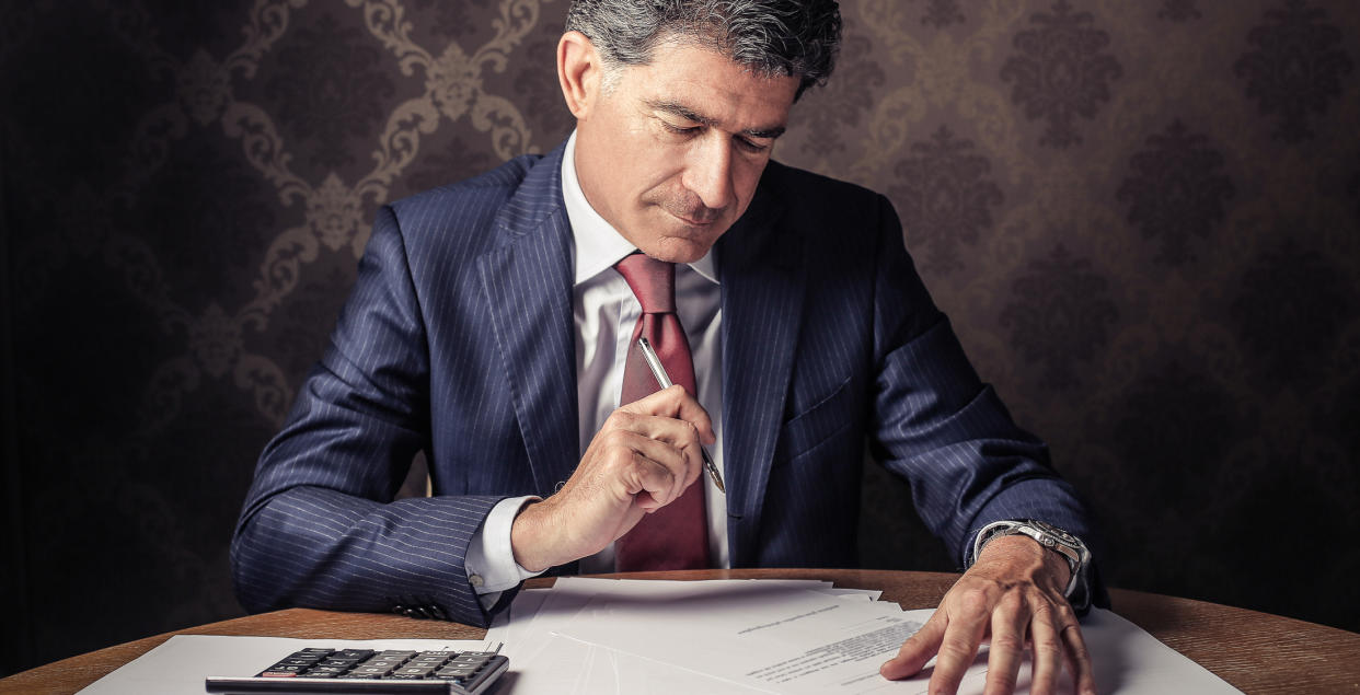 man looking at paperwork and calculator