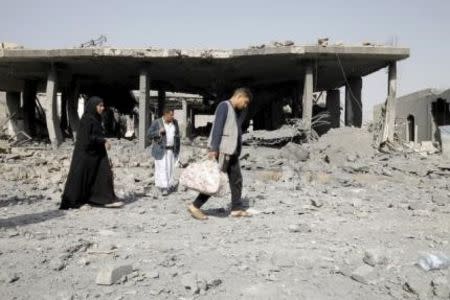 People leave their house after it was destroyed by a Saudi-led air strike in Yemen's capital Sanaa September 5, 2015. REUTERS/Mohamed al-Sayaghi