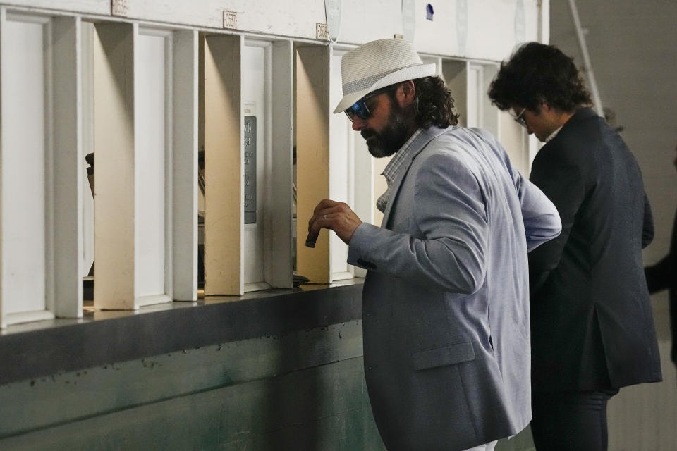 Spectators place bets before the 148th running of the Kentucky Derby horse race at Churchill Downs Saturday, May 7, 2022, in Louisville, Ky. (AP Photo/Charlie Riedel)