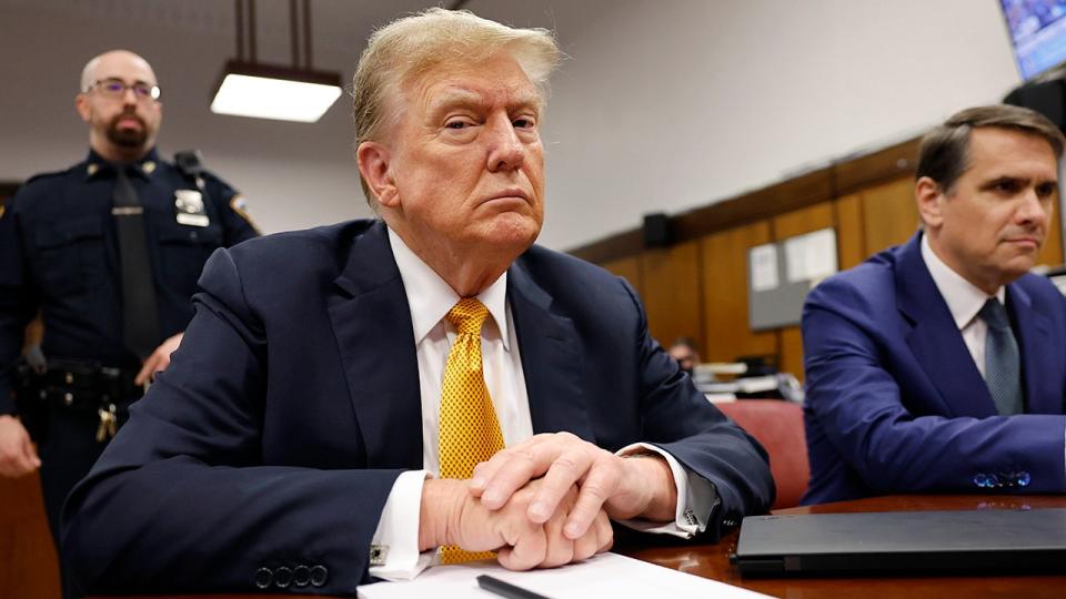 Donald Trump in criminal court in gold tie