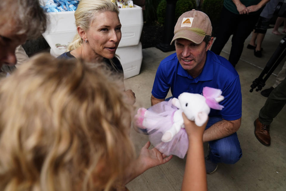 Kentucky Governor Andy Beshear, right, and First Lady Britainy Beshear, left, talk with residents that have been displaced by floodwaters at Jenny Wiley State Resort Park Saturday, Aug. 6, 2022, in Prestonsburg, Ky. (AP Photo/Brynn Anderson)