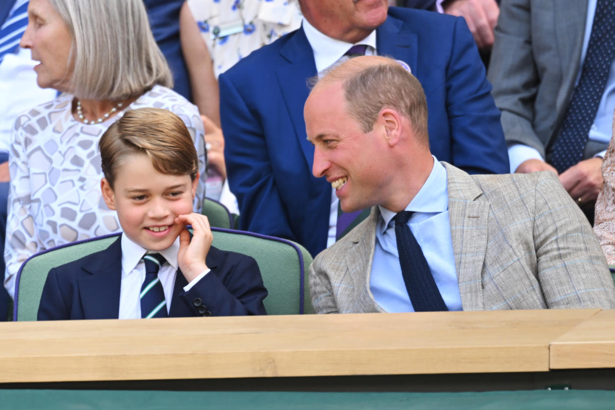 Prince George was seen giggling with his dad, Prince William, as they waited for the men's singles final to start at Wimbledon. (Getty Images)