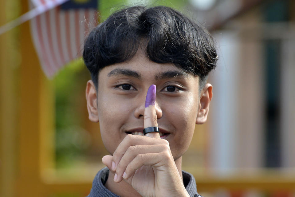 A young voter shows his finger with ink after casting his vote during the general election at a voting center in Alor Setar, Kedah, Malaysia, Saturday, Nov. 19, 2022. Malaysians have begun casting ballots in a tightly contested national election that will determine whether the country’s longest-ruling coalition can make a comeback after its electoral defeat four years ago. (AP Photo/JohnShen Lee)