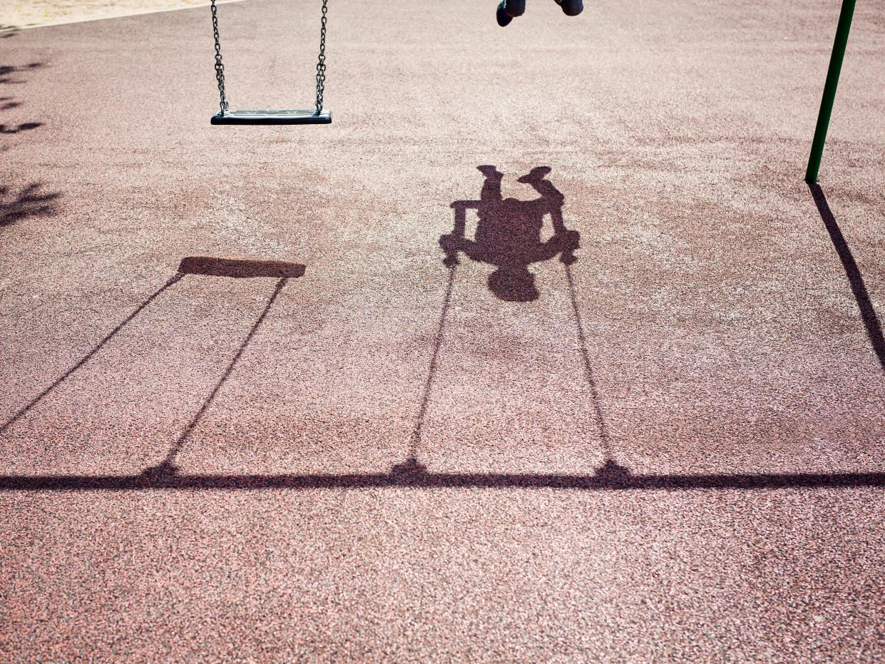 Shadow of a child on a playground swing