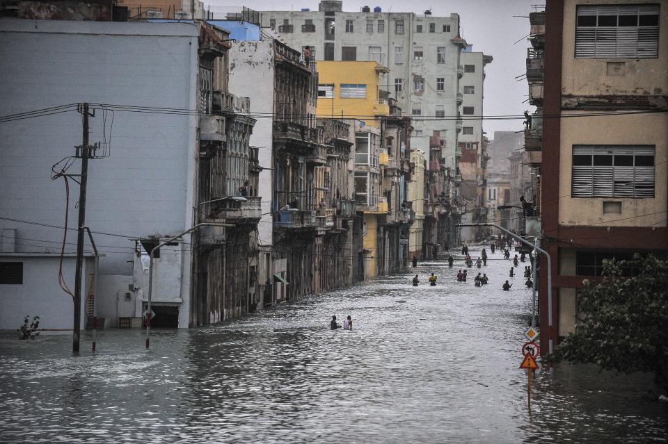 Cubans wade through a flooded street in Havana.