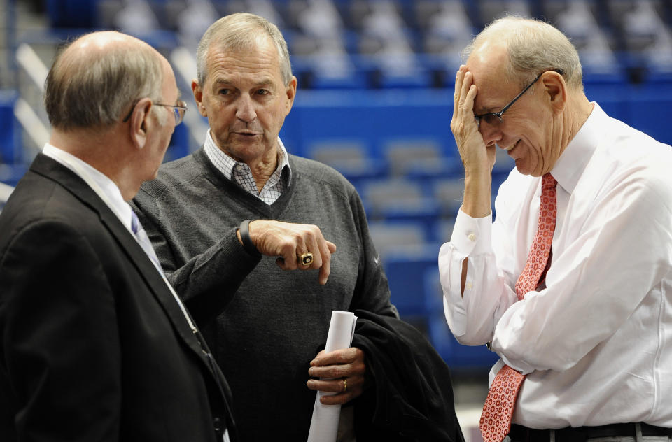 Former Connecticut head coach Jim Calhoun, center, speaks with Associated Press writer Jim O'Connell, left, as Syracuse head coach Jim Boeheim, right, reacts, before an NCAA college basketball game between the two teams in Hartford, Conn., Wednesday, Feb. 13, 2013. (AP Photo/Jessica Hill)