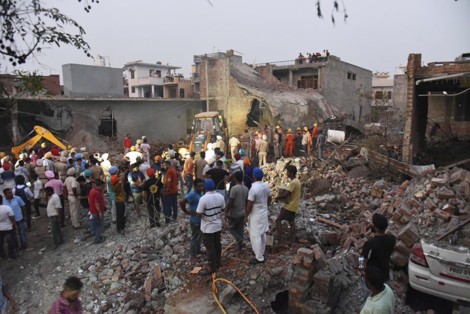 Rescuers work at the site of an explosion at a fireworks factory in Batala, in the northern Indian state of Punjab, Wednesday, Sept. 4, 2019. More than a dozen people were killed in the explosion that caused the building to catch fire and collapse, officials said. (AP Photo/Prabhjot Gill)