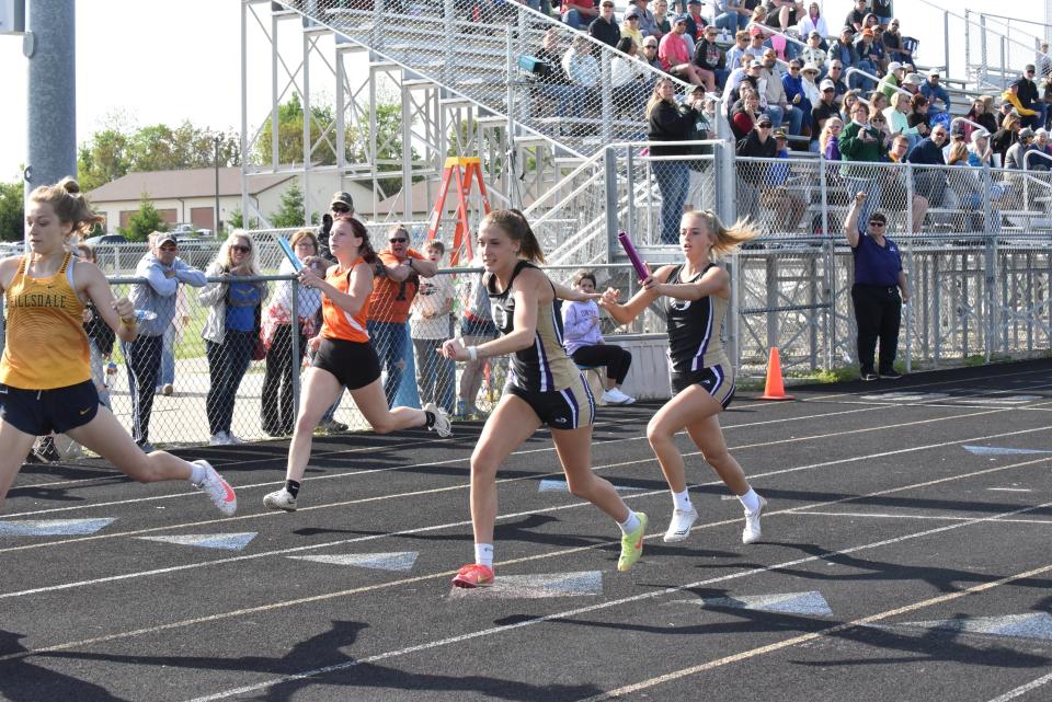 Onsted's Allyson Robarge hands the baton to Kamryn Ross in the 4x200 relay Tuesday at the LCAA championship meet at Onsted.