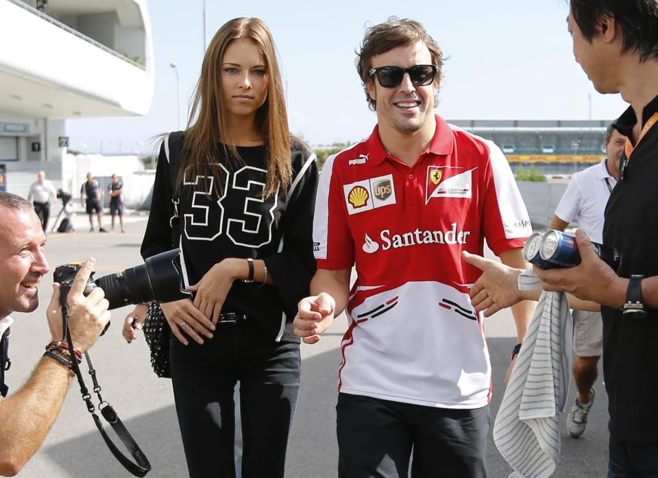 Ferrari Formula One driver Alonso of Spain walks with his girlfriend Kapustina as they arrive at the Suzuka circuit