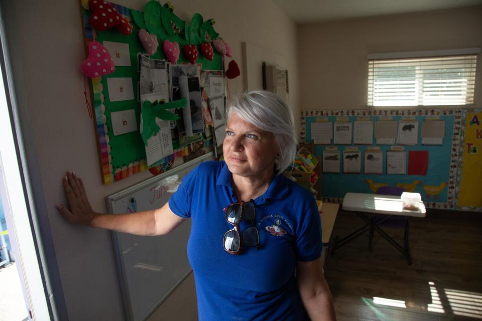 A woman stands inside a classroom.