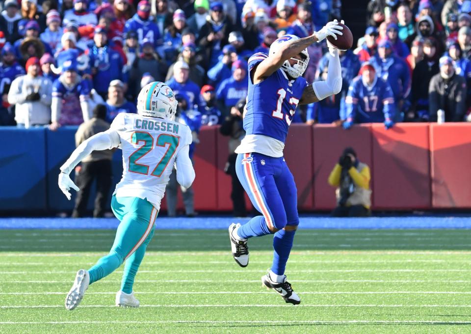 Jan 15, 2023; Orchard Park, NY, USA; Buffalo Bills wide receiver Gabe Davis (13) catches a pass against Miami Dolphins cornerback Keion Crossen (27) during the first half in a NFL wild card game at Highmark Stadium. Mandatory Credit: Mark Konezny-USA TODAY Sports