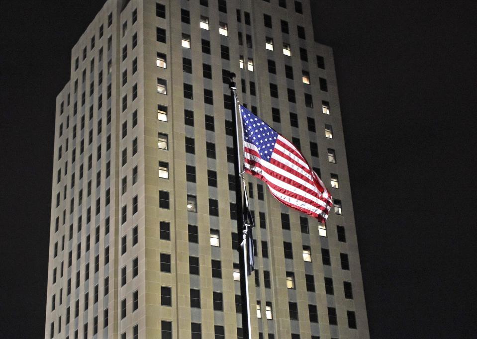 Windows on the state capitol are lit to form a heart visible in a large area of Bismarck, N.D., on Thursday night, March 11, 2021, to commemorate one year since the first case of COVID-19 was identified in North Dakota. (Tom Stromme/The Bismarck Tribune via AP)