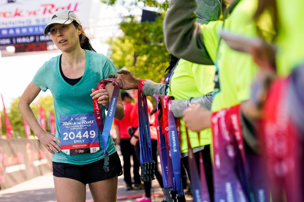 Emily Lewis receives her medal after finishing the St. Jude Rock 'n' Roll Marathon in Nashville, Tenn., Saturday, April 22, 2023.