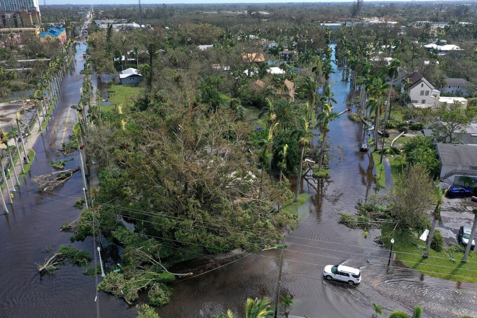 In this aerial view, vehicles make their way through a flooded area after Hurricane Ian passed through on September 29, 2022 in Fort Myers, Florida. The hurricane brought high winds, storm surge and rain to the area causing severe damage.