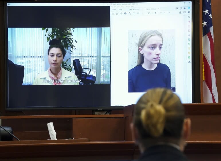 Actor Johnny Depp listens as Raquel Pennington testifies in a previously recorded video deposition, as a picture of Amber Heard is seen on screen, in the courtroom at the Fairfax County Circuit Courthouse in Fairfax, Va., Wednesday, May 18, 2022. Actor Johnny Depp sued his ex-wife Amber Heard for libel in Fairfax County Circuit Court after she wrote an op-ed piece in The Washington Post in 2018 referring to herself as a "public figure representing domestic abuse." (Kevin Lamarque/Pool Photo via AP)