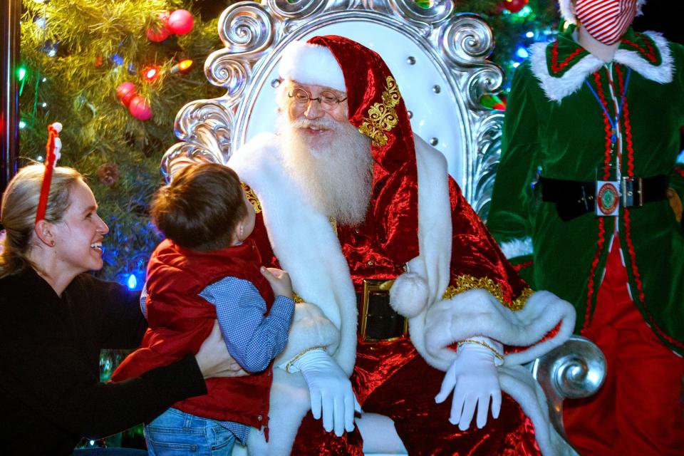 Nydia Martin, left, smiles as her son Santos, 4, meets Santa for the first time during the La Quinta Tree Lighting Ceremony at Civic Center Campus in La Quinta, Calif., on December 3, 2021. 